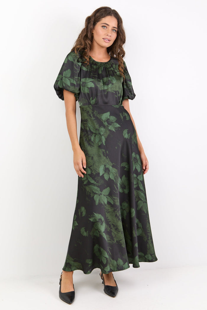 Woman wearing a green and black patterned dress on a white background