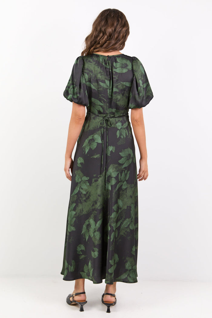 Woman wearing a green and black patterned dress on a white background