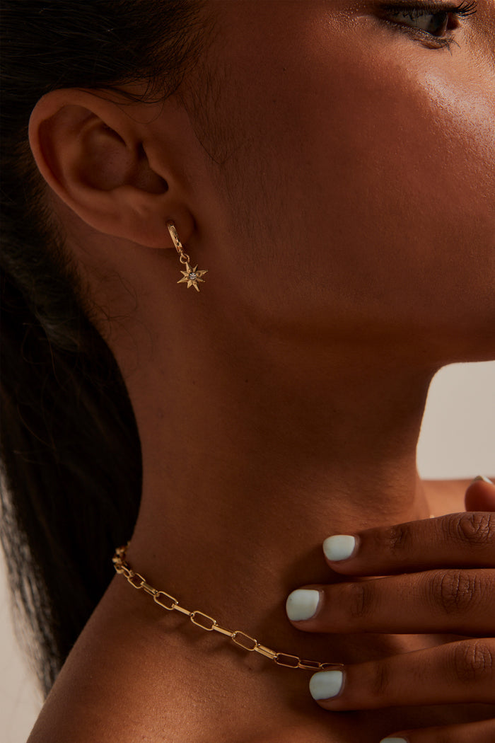 Model wears star pendant earring