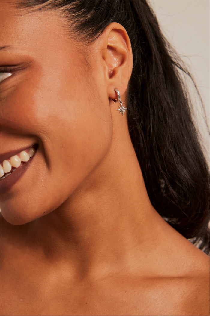 Model wears star earring.