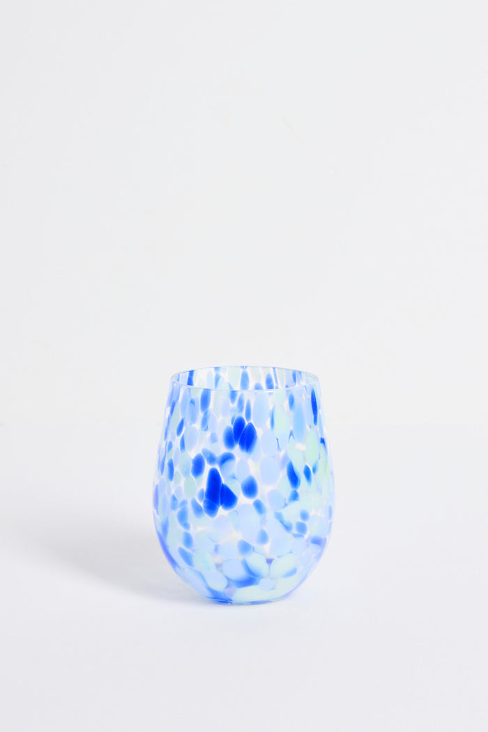 Blue and white speckled glass vase on a light gray background