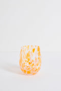 Stemless wine glass with orange and white marbled pattern on a light gray background