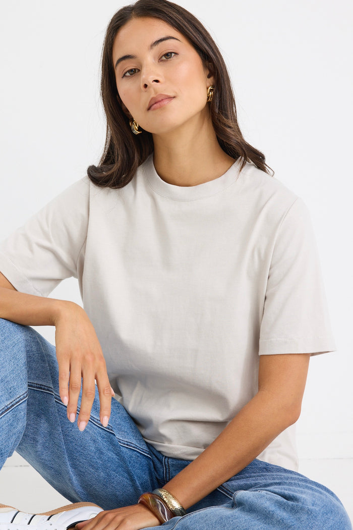 model wears a off white t-shirt with light blue jeans