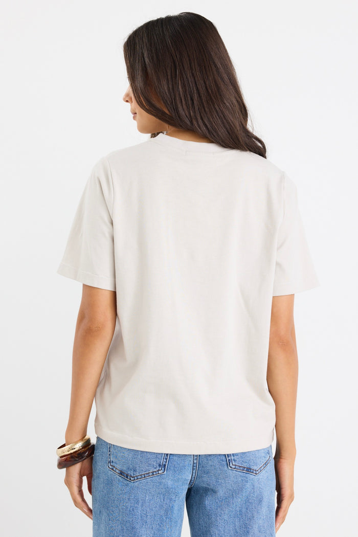 model wears a off white t-shirt with light blue jeans