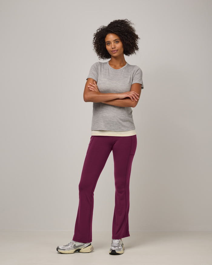 Model wearing Summit Straight Cut Pocket Legging in Plum, a purplish-red color. Summit Straight Cut Pocket Legging is a merino wool legging with pockets available in sizes XS-3X Regular, S-XXL Long.