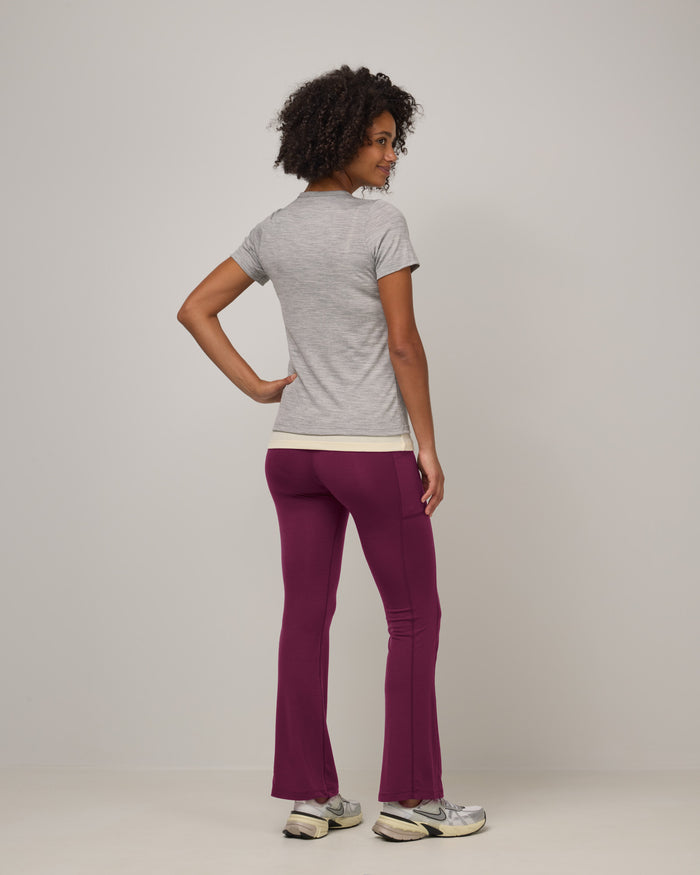 Model wearing Summit Straight Cut Pocket Legging in Plum, a purplish-red color. Summit Straight Cut Pocket Legging is a merino wool legging with pockets available in sizes XS-3X Regular, S-XXL Long.