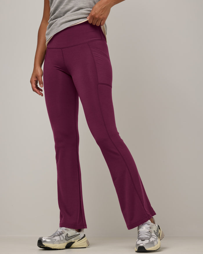 Model wearing Summit Straight Cut Pocket Legging in Plum, a purplish-red color. Summit Straight Cut Pocket Legging is a merino wool legging with pockets available in sizes XS-3X Regular, S-XXL Long.