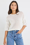 model wears a white knit t-shirt and a light blue jean