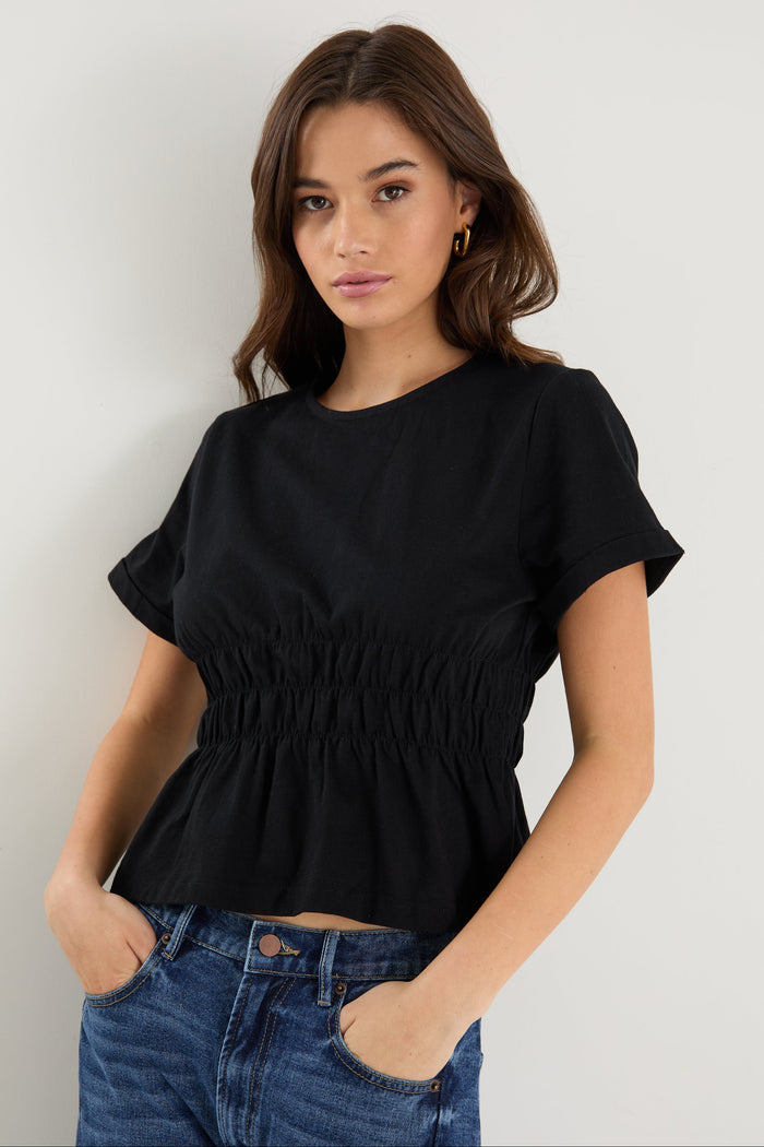 model wearing black shirt and blue jeans