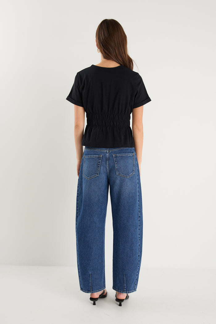 model wearing black shirt and blue jeans