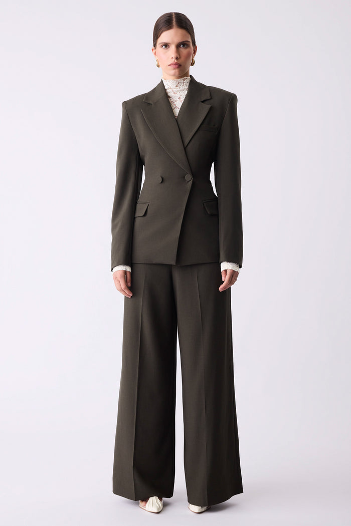 Woman wearing a dark green suit on a white background