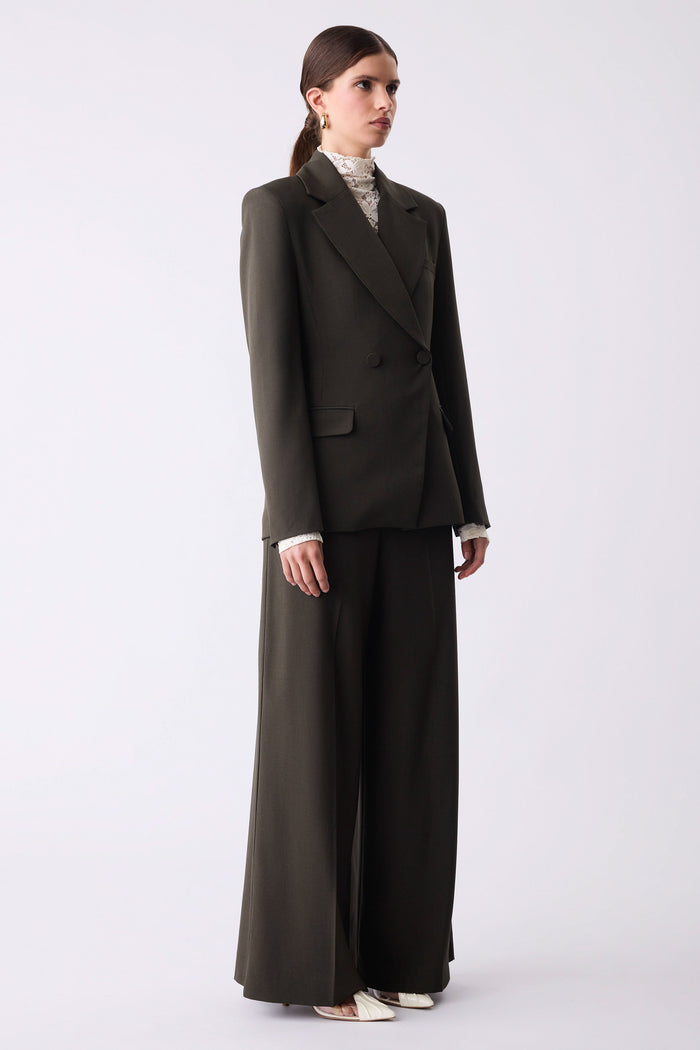 Woman wearing a dark gray suit on a white background