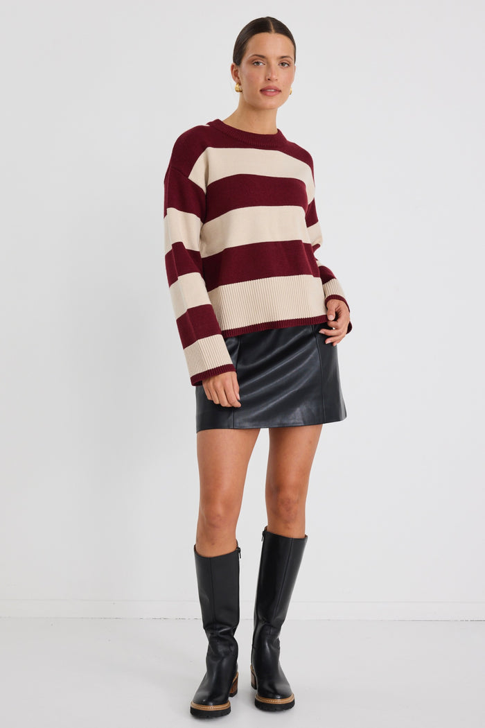 Model wears a black leather short mini skirt with stripe jumper