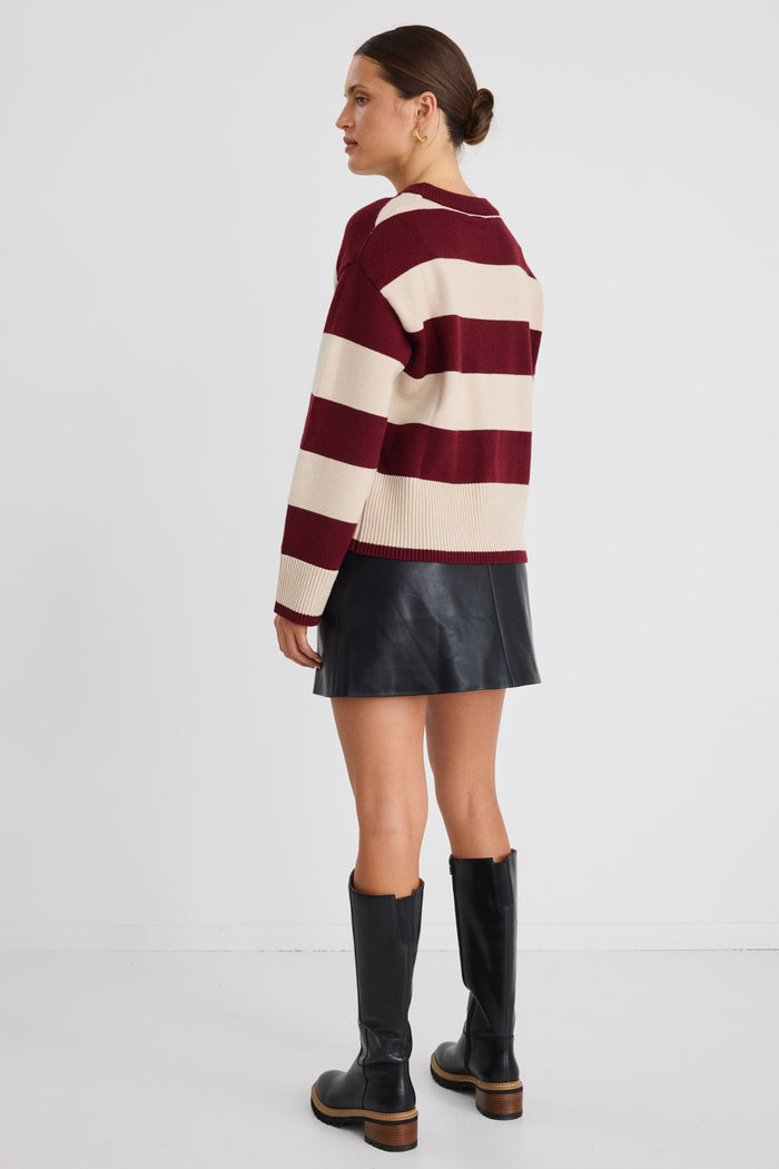 Model wears a black leather short mini skirt with stripe jumper