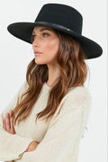 Woman wearing a black hat against a white background