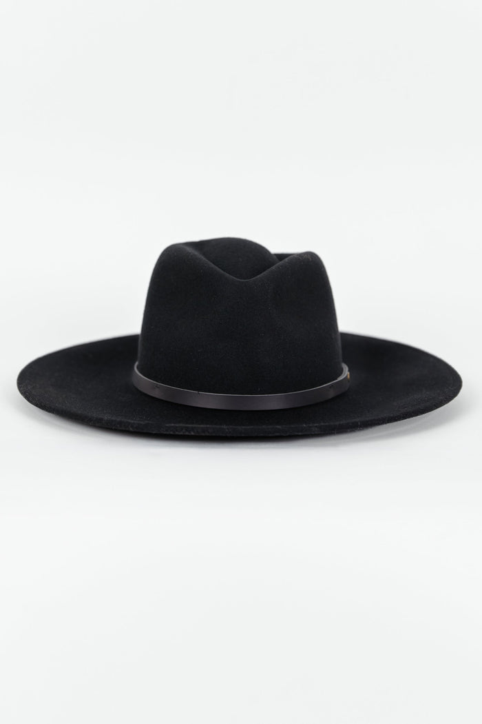 Woman wearing a black hat against a white background