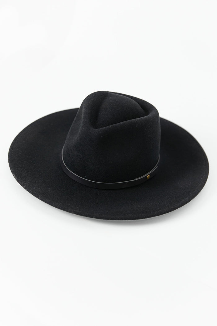 Woman wearing a black hat against a white background
