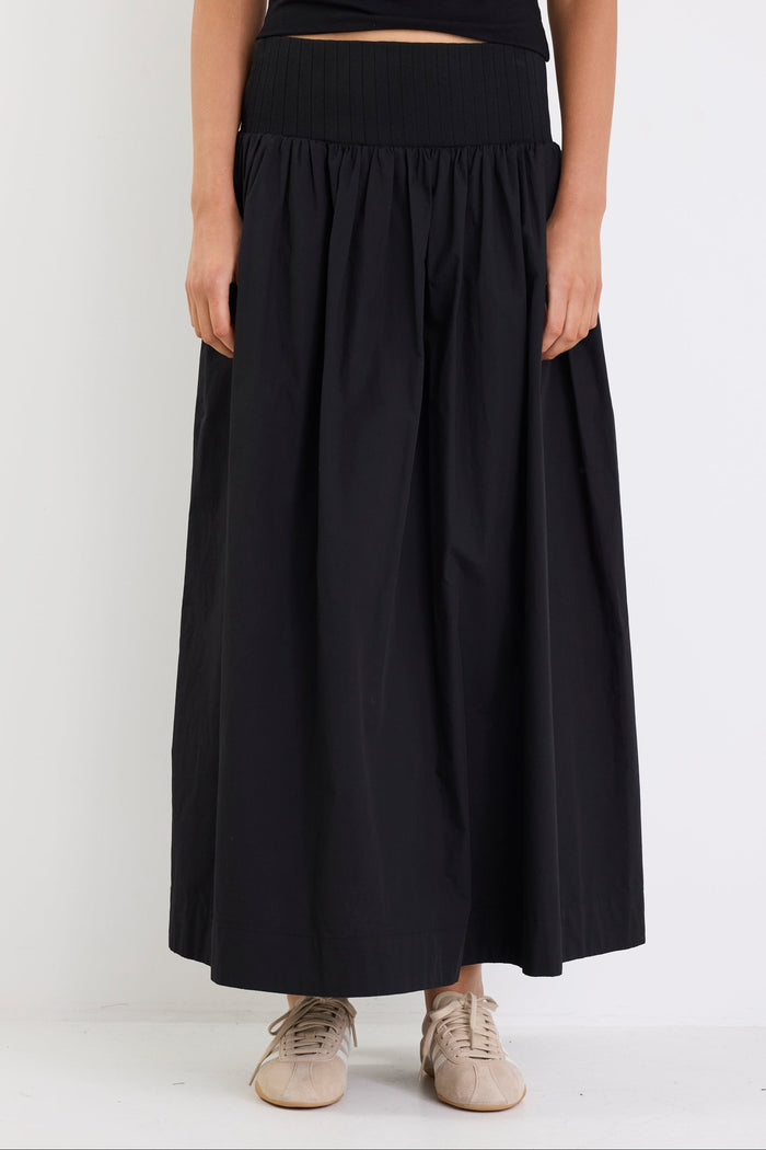 Person wearing a black skirt with a white background