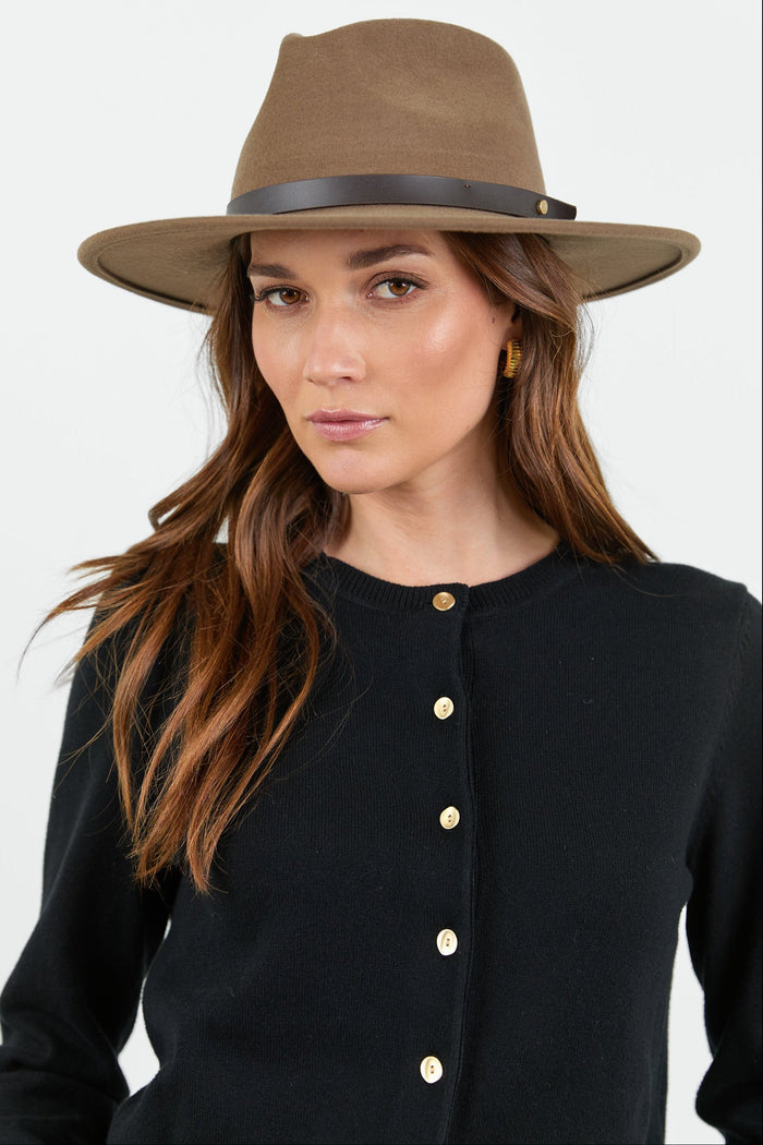 Woman wearing a brown hat against a white background