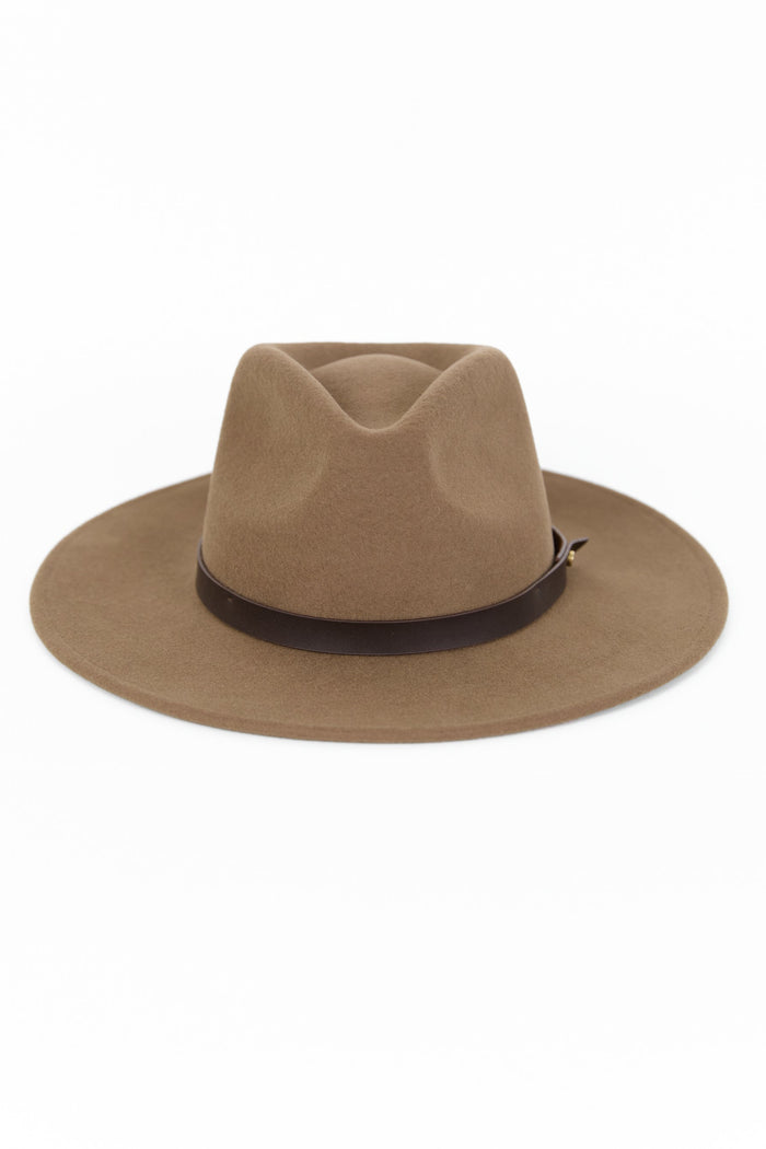 Woman wearing a brown hat against a white background