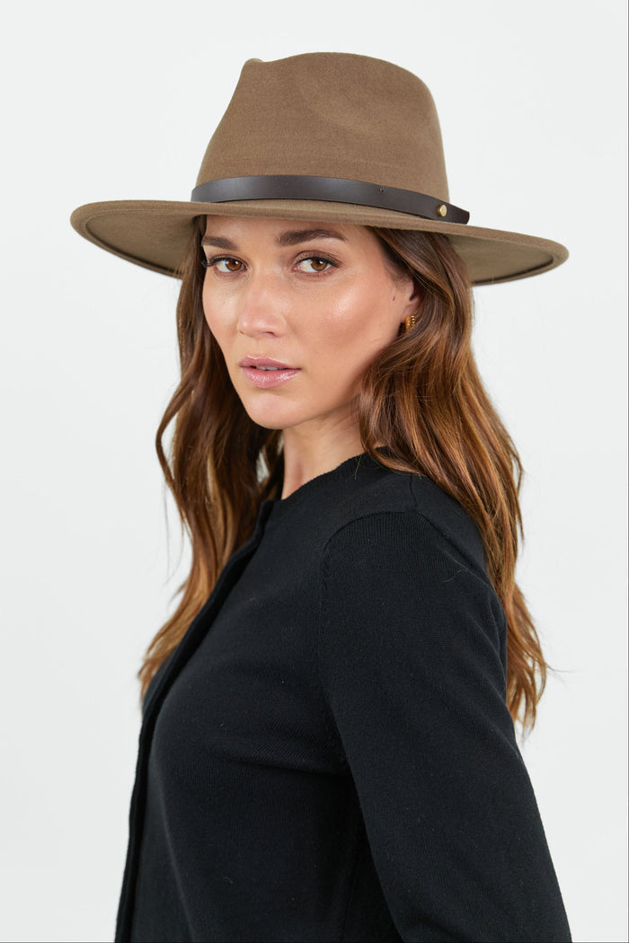 Woman wearing a brown hat against a white background