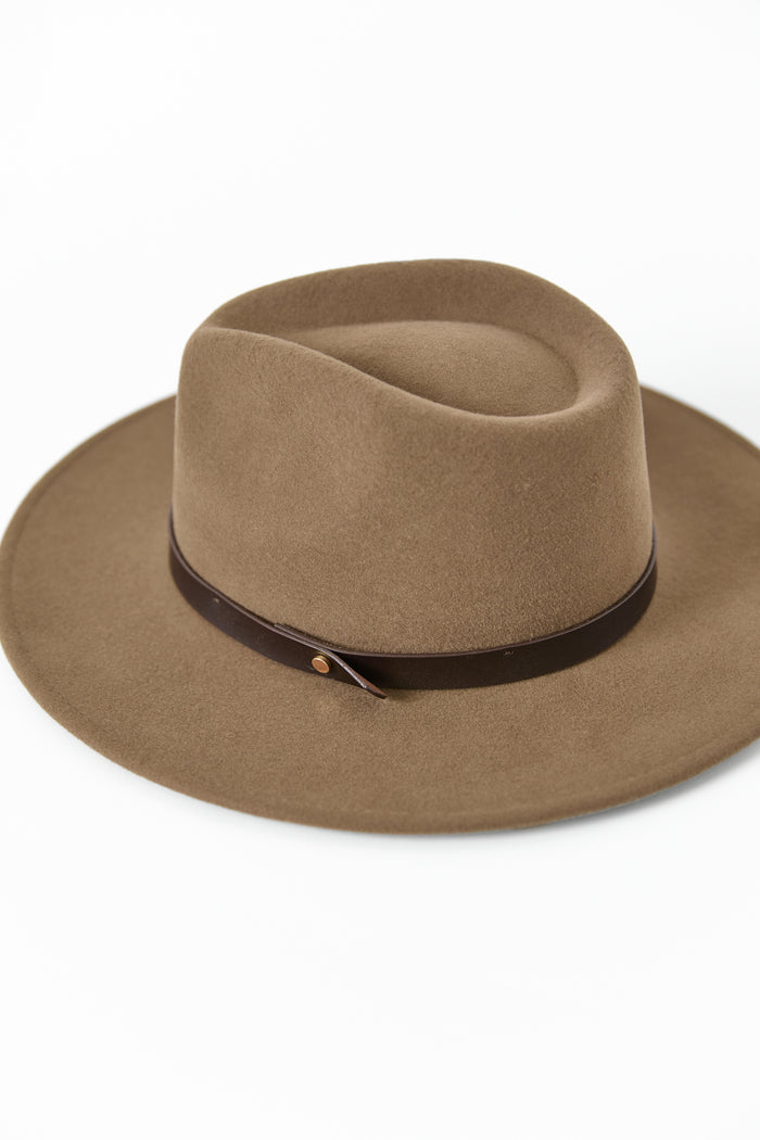 Woman wearing a brown hat against a white background