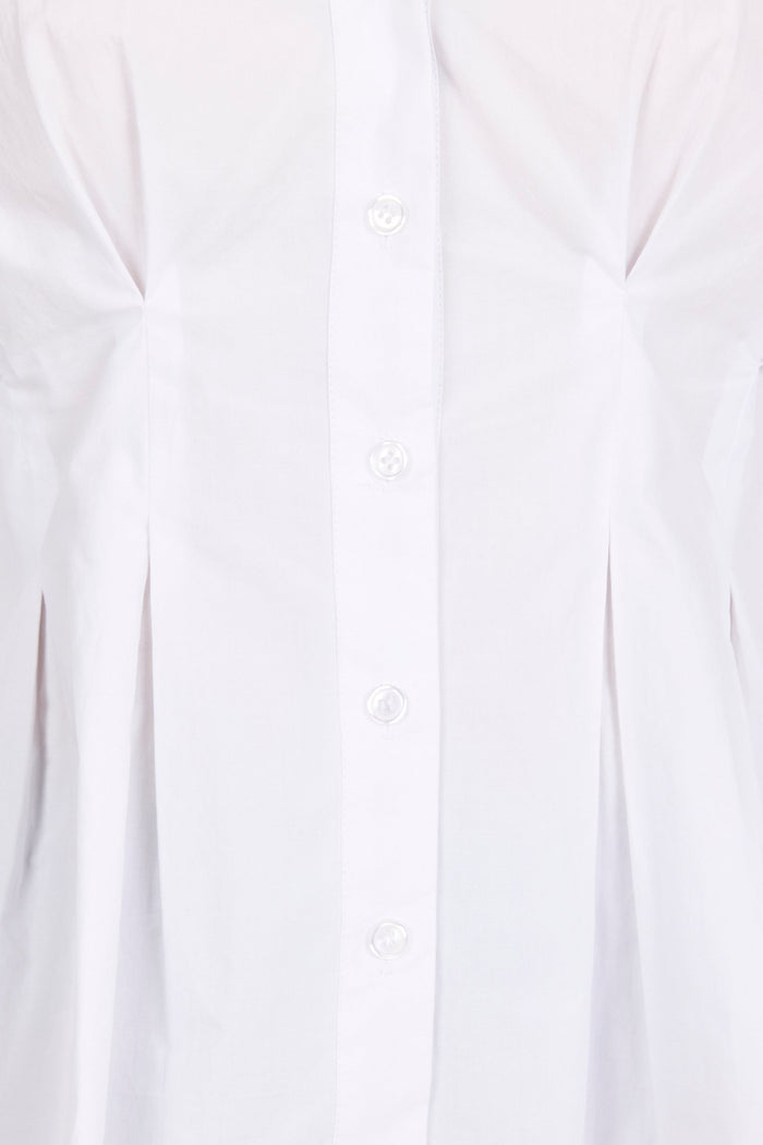 Close-up of a white long-sleeve button-up shirt with a vertical button placket and gathered side seams.