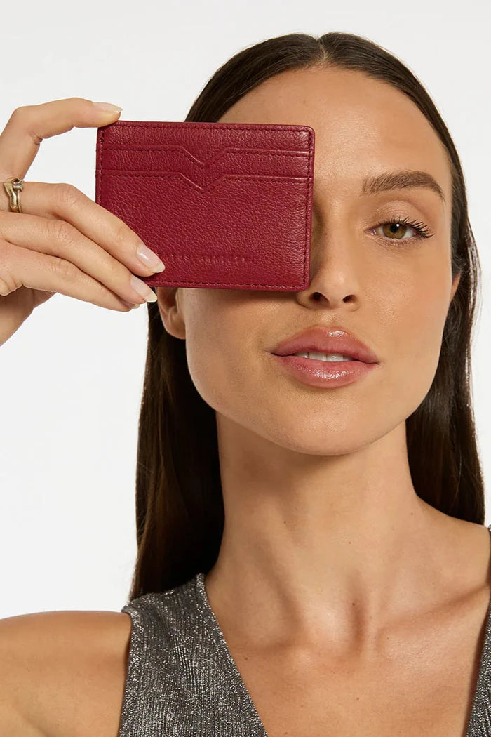 Model holding red card wallet