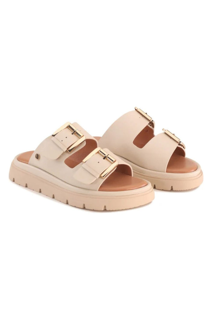 A pair of beige double-strap platform slide sandals with gold-tone buckle details, shown against a plain white background.