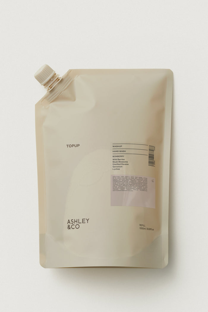 Beige plastic bottle with a pump on a white background, featuring the brand 'Ashley & Co'.