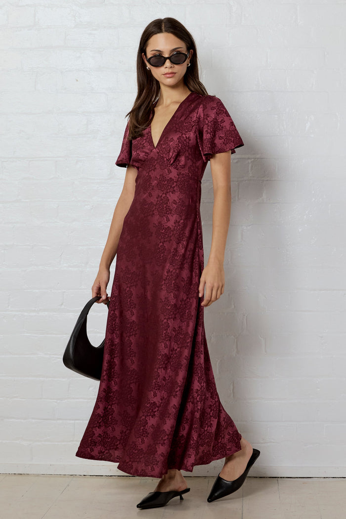 Woman wearing a burgundy dress with a white background