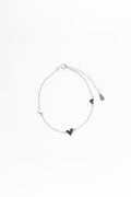 Silver bracelet with heart-shaped charms on a white background