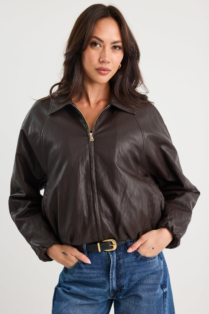 Woman wearing a brown leather jacket and blue jeans on a white background
col_pattern