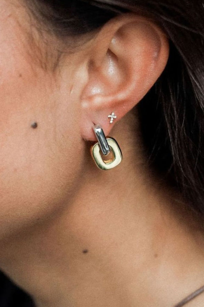 Close-up of U-shaped two tone gold and silver hoop earrings.