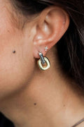 Close-up of U-shaped two tone gold and silver hoop earrings.