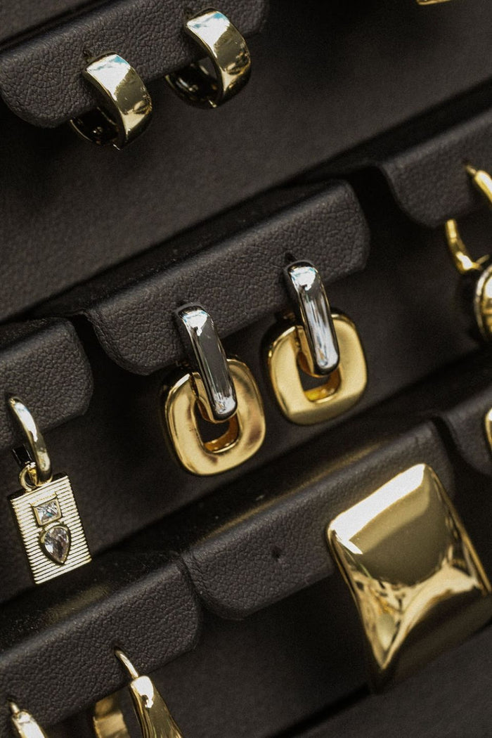 Close-up of U-shaped two tone gold and silver hoop earrings.
