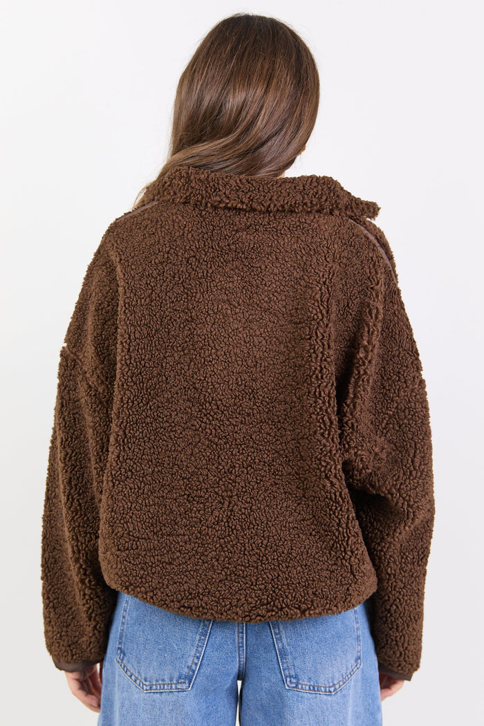Person wearing a brown teddy jacket and blue jeans on a white background
col_pattern