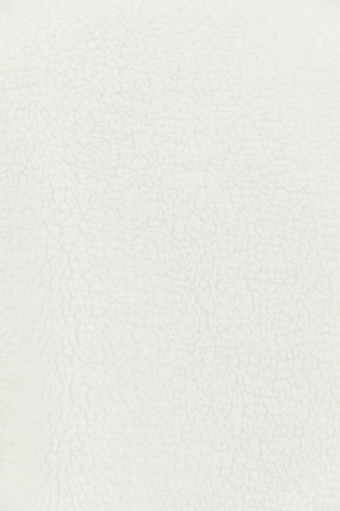 This cozy cream fleece jacket features a zip-up front, sporty black side stripes, and a relaxed fit, paired with black wash jeans for a casual yet stylish look.
