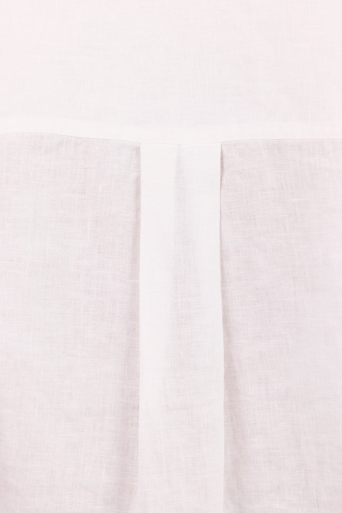 A close-up of a light off-white or cream textured fabric with a central vertical pleat or fold running down the middle.
col_pattern