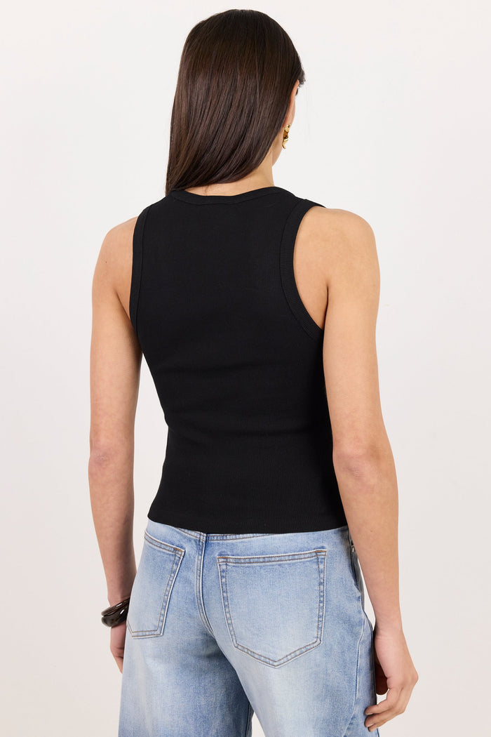 A woman viewed from behind wearing a fitted black sleeveless top and light blue jeans against a plain white studio background.