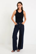 Woman wearing dark denim jean and black singlet