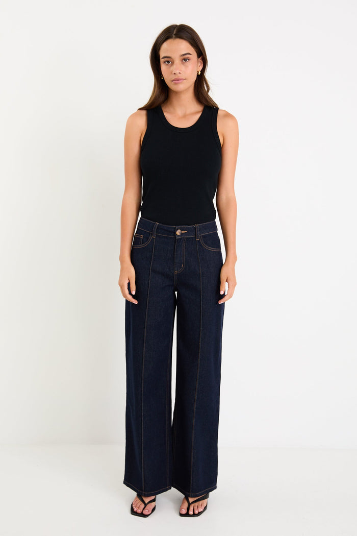 Woman wearing dark denim jean and black singlet