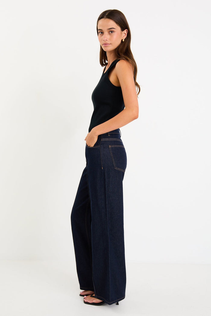 Woman wearing dark denim jean and black singlet