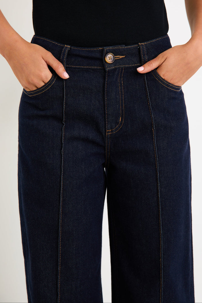 Woman wearing dark denim jean and black singlet