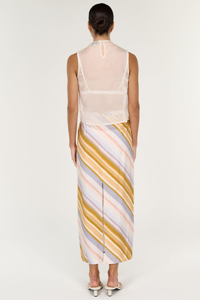 Woman wearing a sleeveless top and striped skirt on a white background