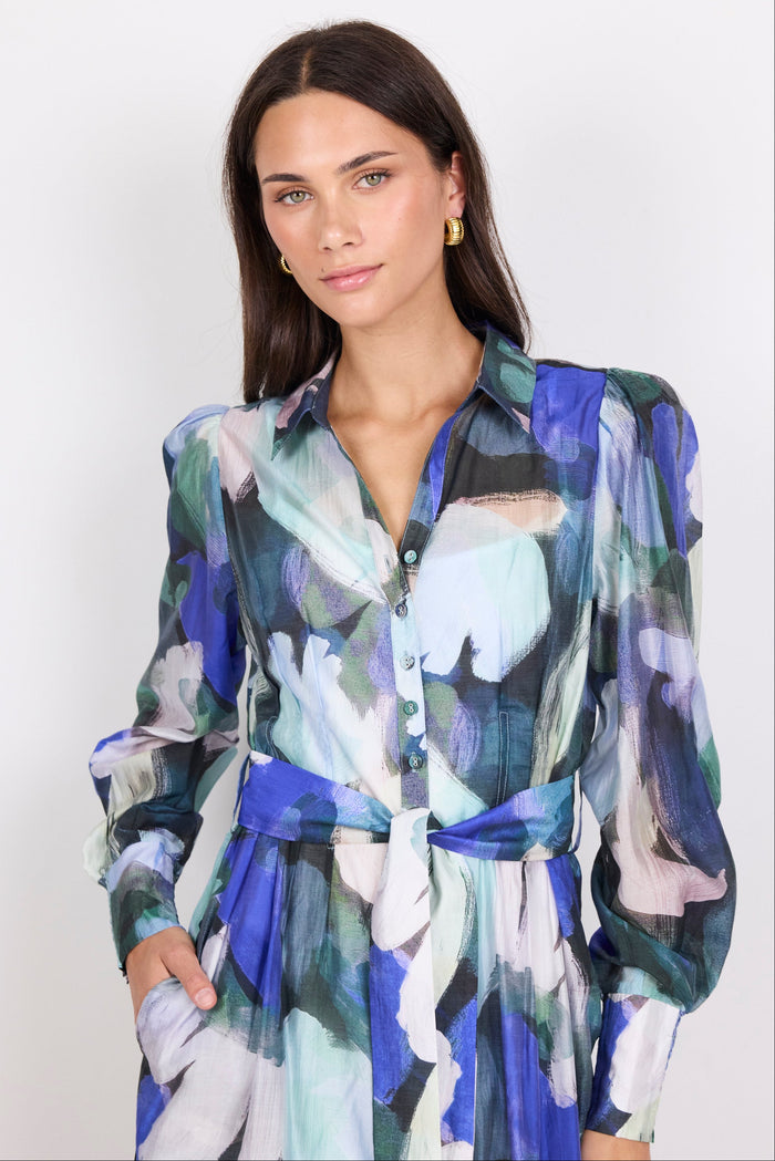Woman wearing a colourful print dress against a white background