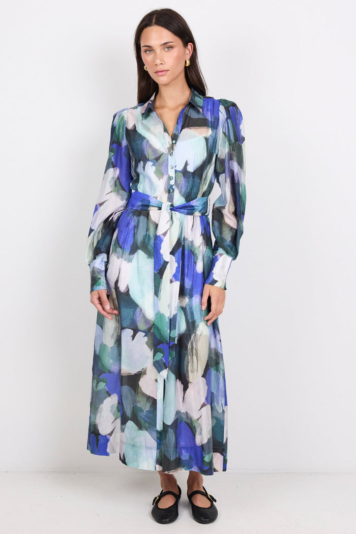 Woman wearing a long print dress on a white background