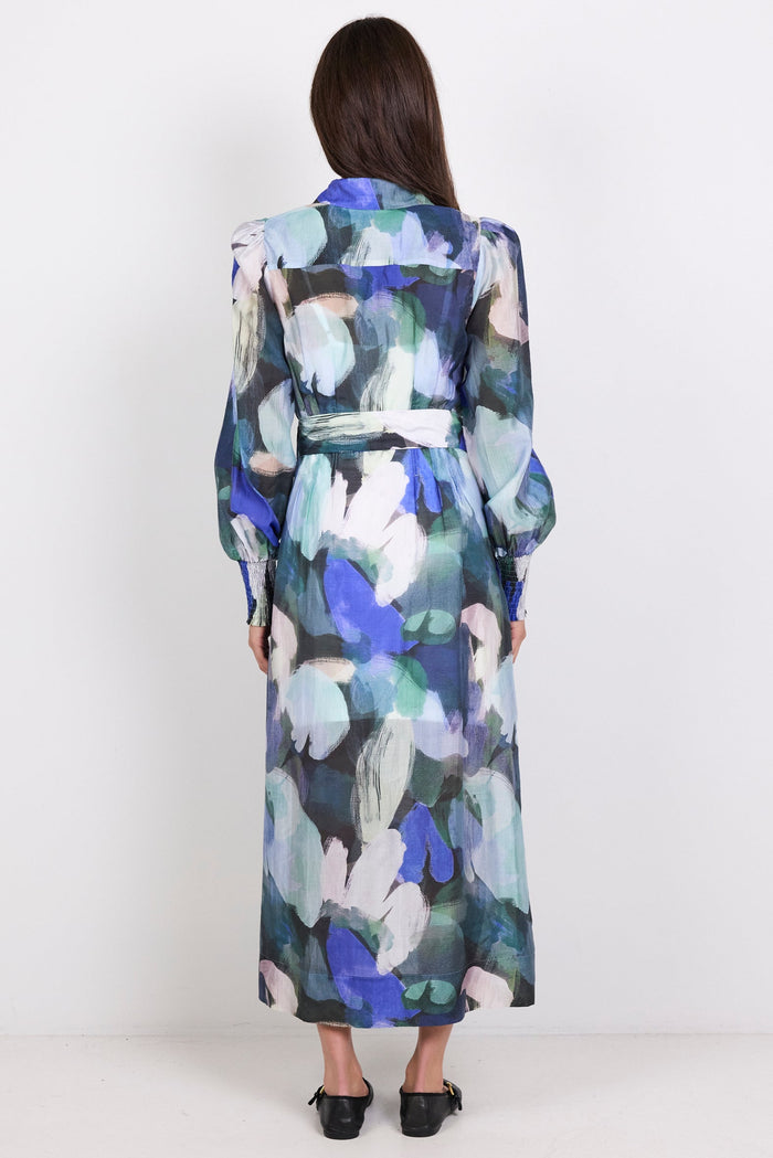 Woman wearing a long print dress with a white background
