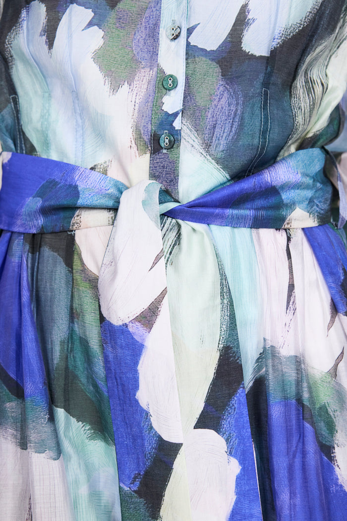 Close-up of an abstract print dress with a blue belt