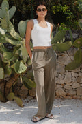 Woman wearing khaki wide-leg drawstring pants with an elastic waist, featuring a relaxed fit and side stripe detail, styled with a plain white tee